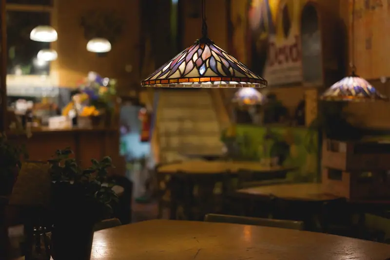 Luminária de vitral pendurada sobre uma mesa de restaurante