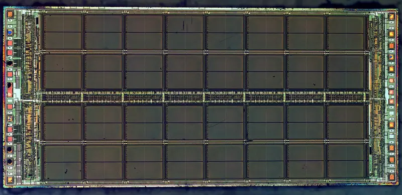 Fotografia microscópica do circuito de um chip de memória, com padrões geométricos coloridos
