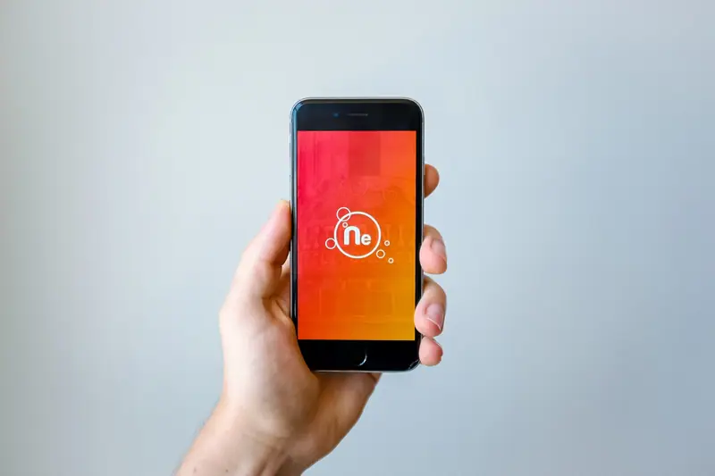 Mão segurando um smartphone com a tela colorida acesa